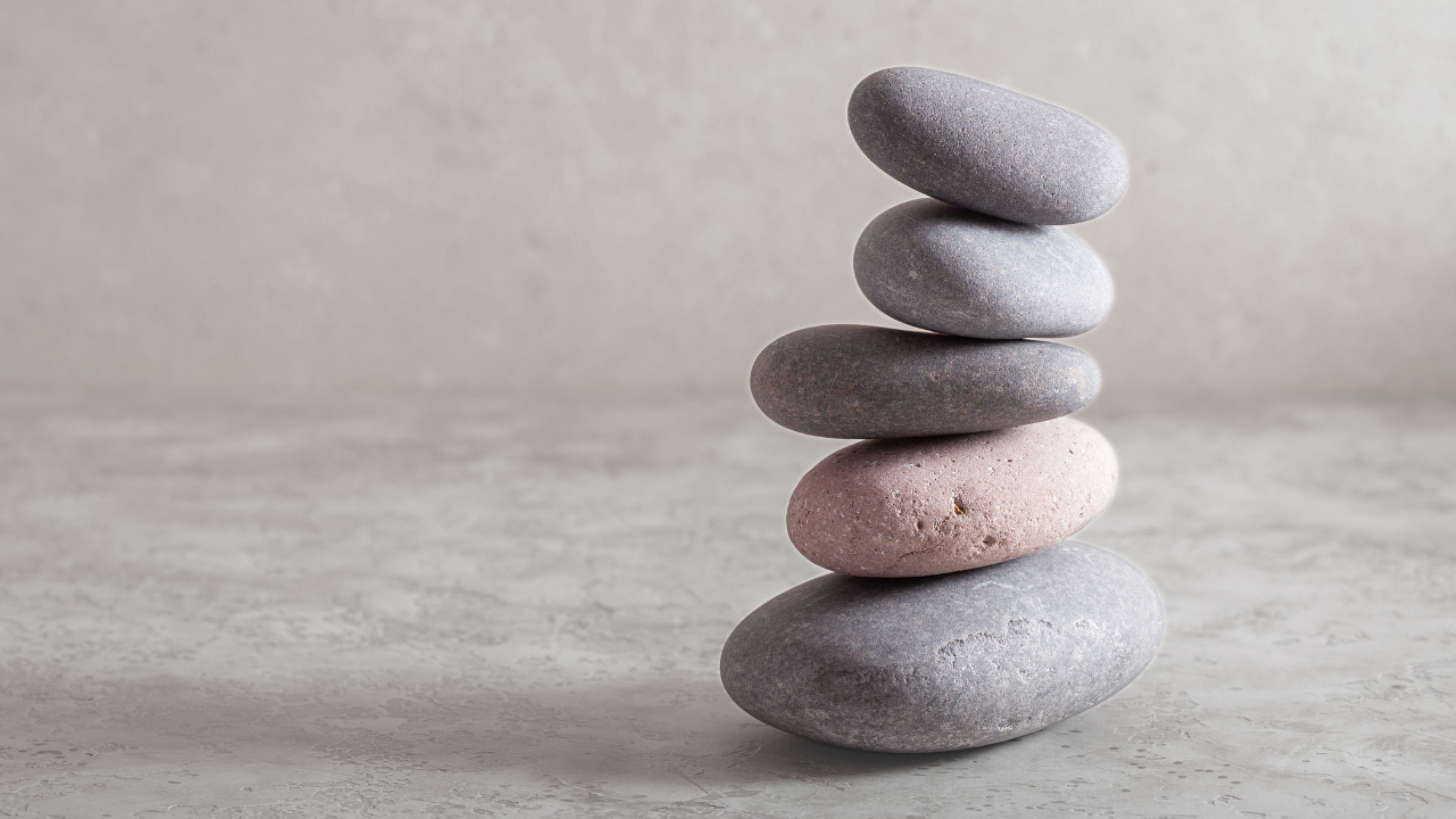 Stone stack symbolising balance, restoration and relief, introducing Peter Mamo’s remedial massage and headache treatments.